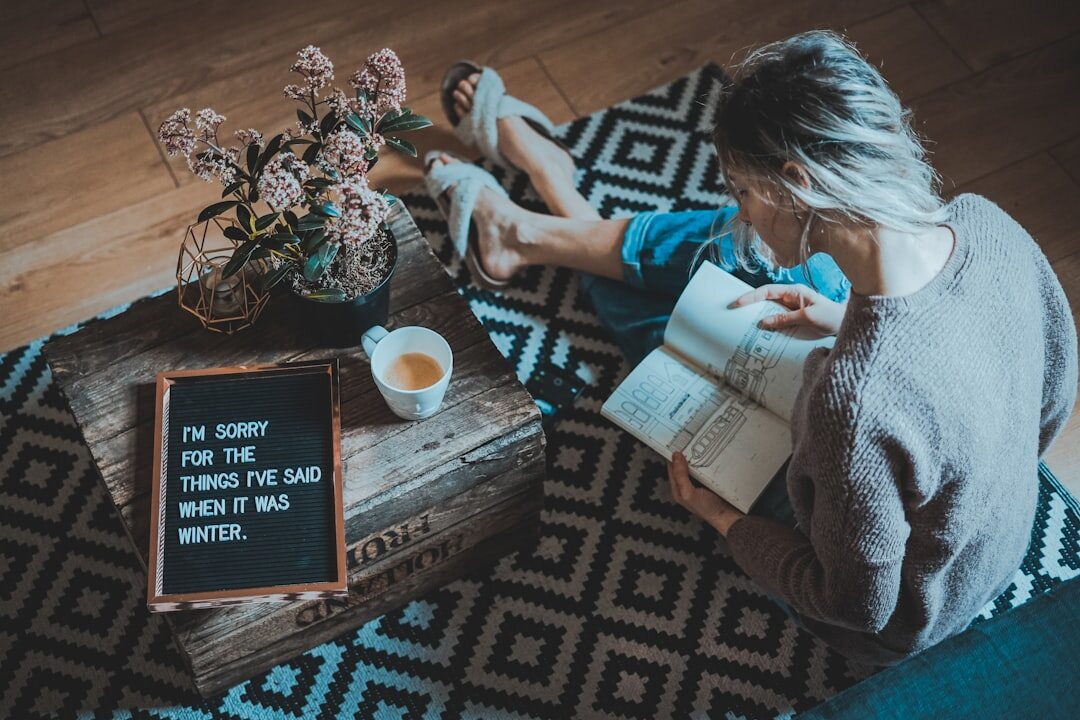Senior woman reading a newspaper and enjoying a cup of tea at home