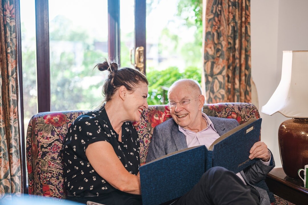 Senior man and woman reviewing an events brochure together with a helper